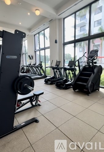 A gym with a variety of equipment including treadmills, weights, and exercise machines.