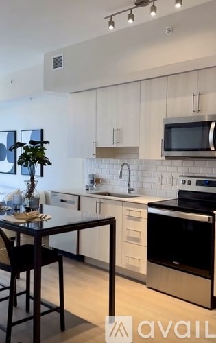 A kitchen with white cabinets and a black counter.