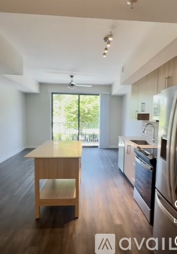 A kitchen with a wooden island and stainless steel appliances.