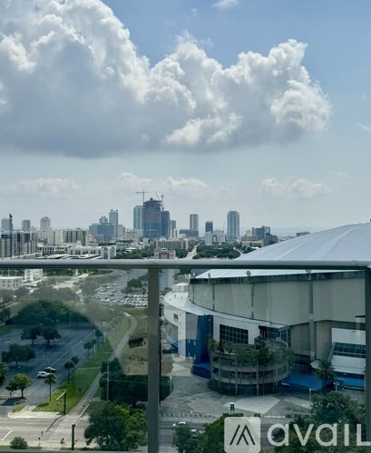 A cityscape with a cloudy sky and a building with the word "avail" on it.