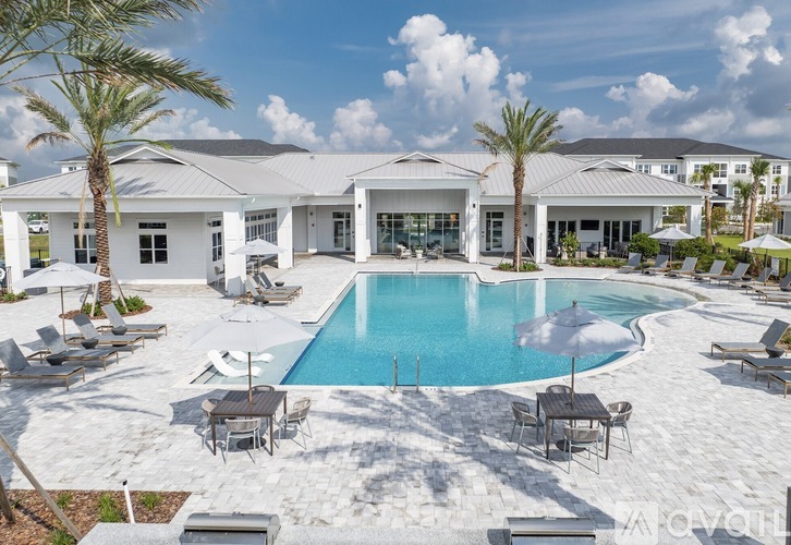 A large white house with a pool in the middle of a patio.