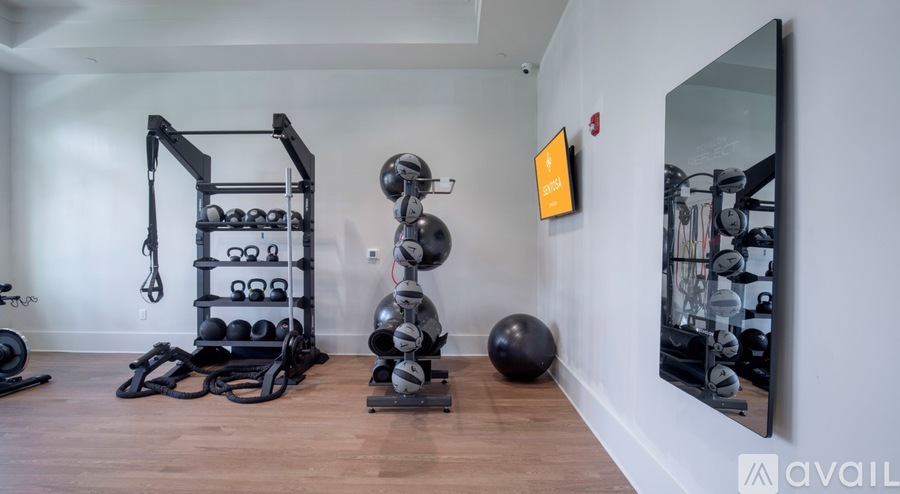 A gym room with a mirror, weights, and exercise equipment.