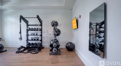 A gym room with a mirror, weights, and exercise equipment.