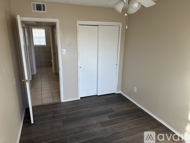 A room with a white door and a white ceiling fan.