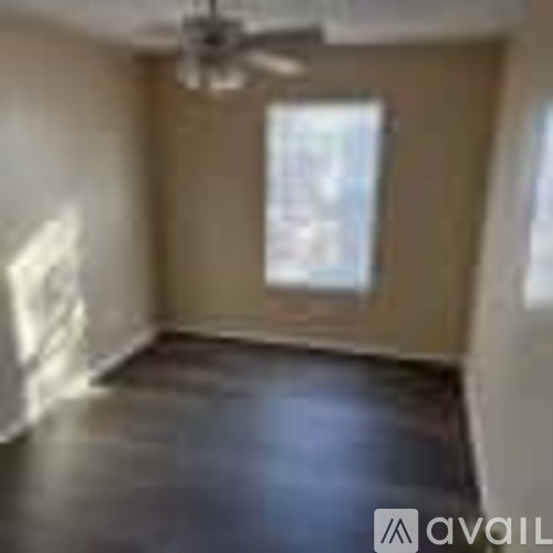 A room with a ceiling fan and a window.