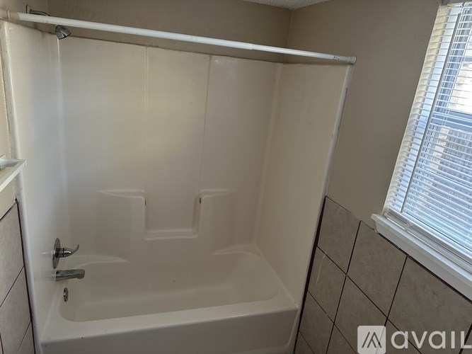 A white bathtub with a shower curtain rod above it.