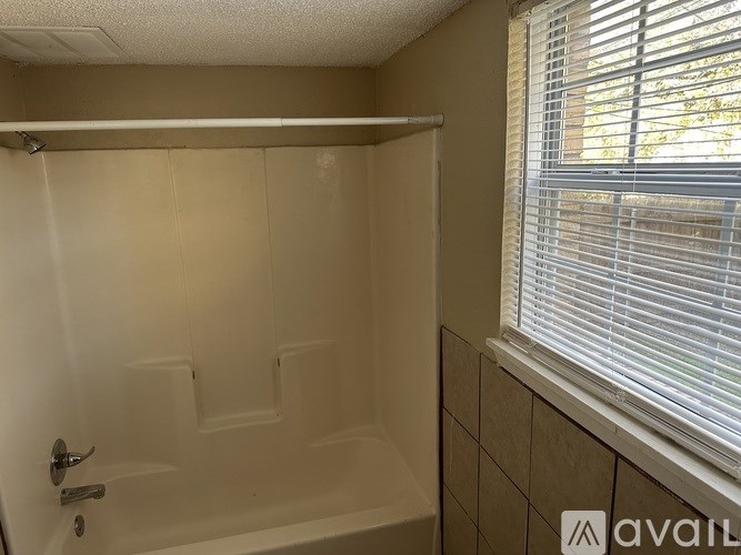 A bathroom with a tub, toilet, and sink.