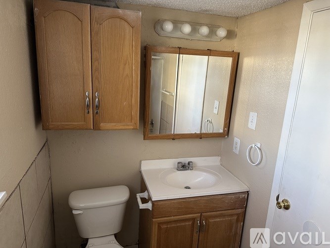 A bathroom with a toilet, sink, and medicine cabinet.