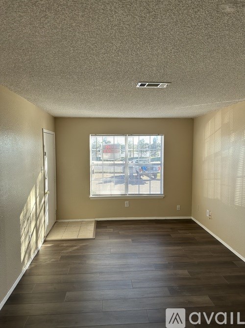 A room with a window and wooden floors.