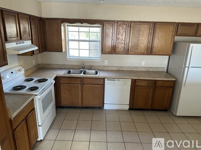 A kitchen with wooden cabinets and white appliances.