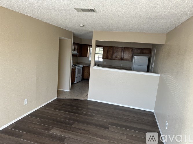 A room with a kitchen in the background and a white counter in the foreground.