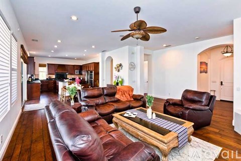 A living room with a brown leather couch and a wooden coffee table.