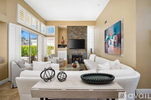 A living room with a fireplace and a painting on the wall.
