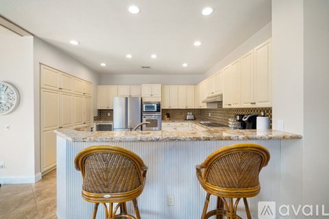 Two chairs are placed in front of a kitchen island.