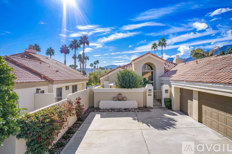 A sunny day in a residential area with houses and palm trees.