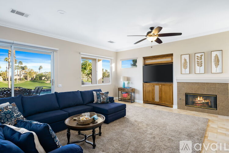 A living room with a blue sofa and a fireplace.