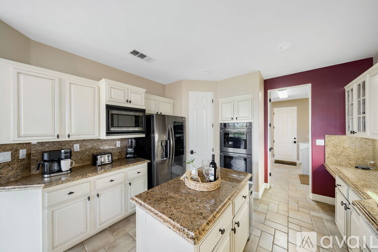 A kitchen with white cabinets and a granite countertop.