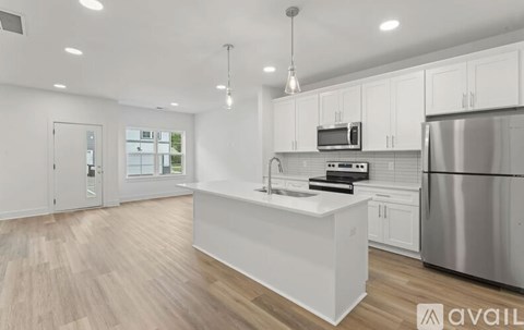 A modern kitchen with white cabinets and stainless steel appliances.