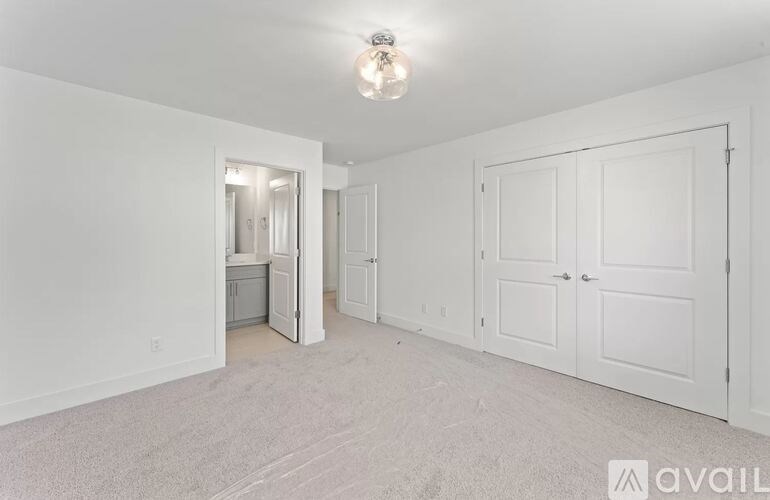 A white room with a carpeted floor and a light on the ceiling.