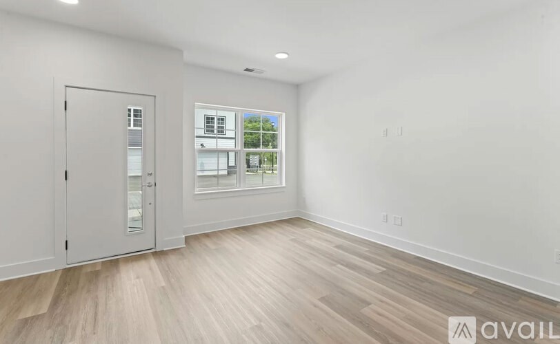 A room with a white wall and a wooden floor.