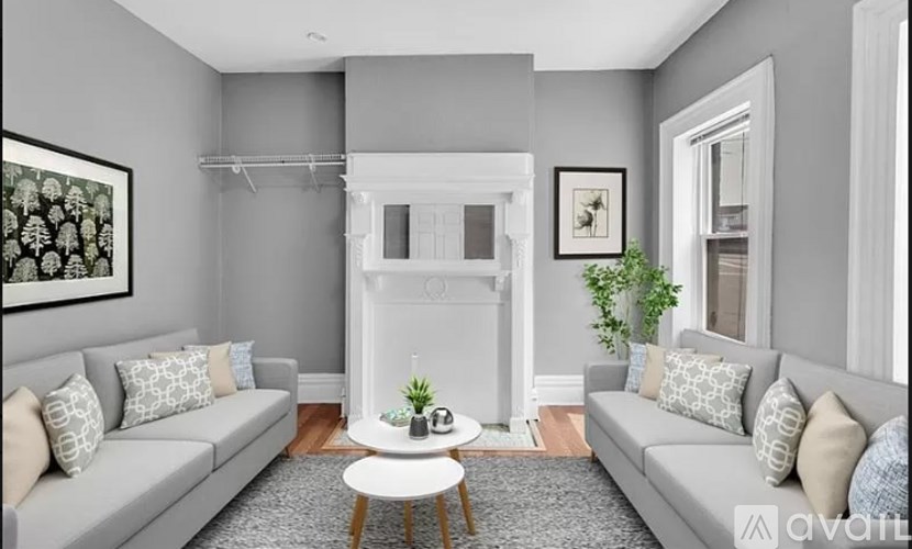 A living room with a grey couch, a white coffee table, and a fireplace.
