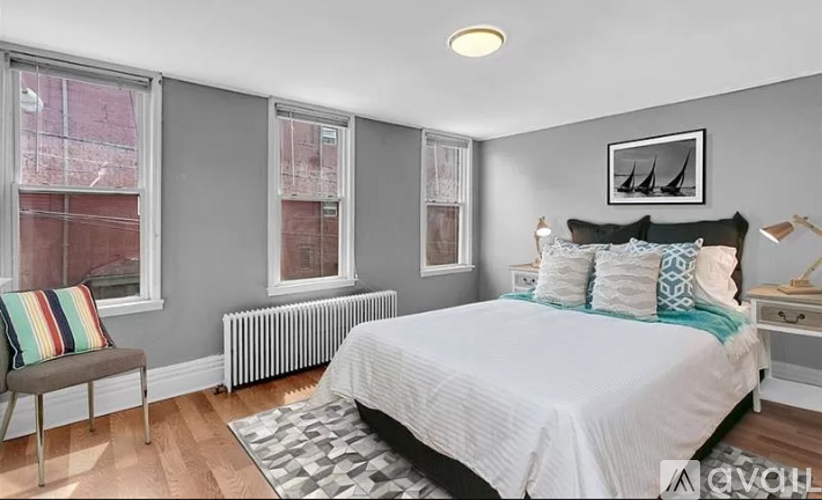 A bedroom with a large bed and a window with a view of a red building.