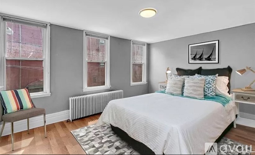A bedroom with a large bed and a window with a view of a red building.