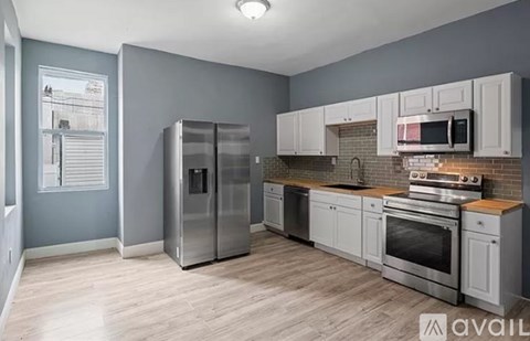 A kitchen with a refrigerator, oven, and microwave.