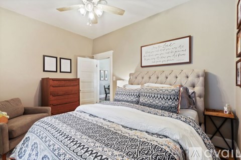 A bedroom with a large bed and a dresser.
