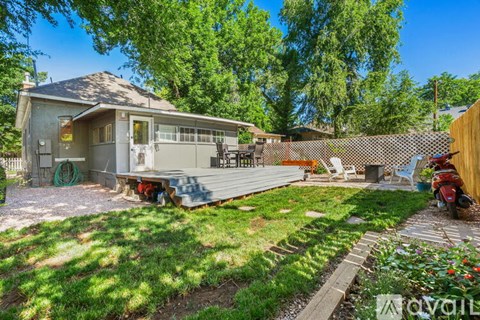 A house with a backyard and a motorcycle parked in the driveway.