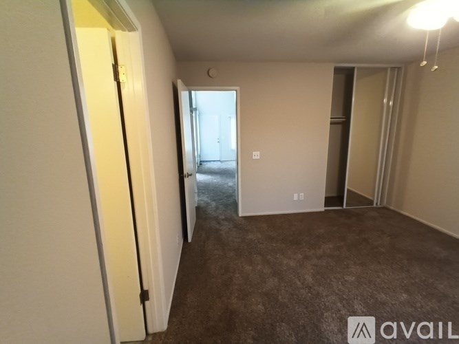 A room with a carpeted floor and a door on the left side.