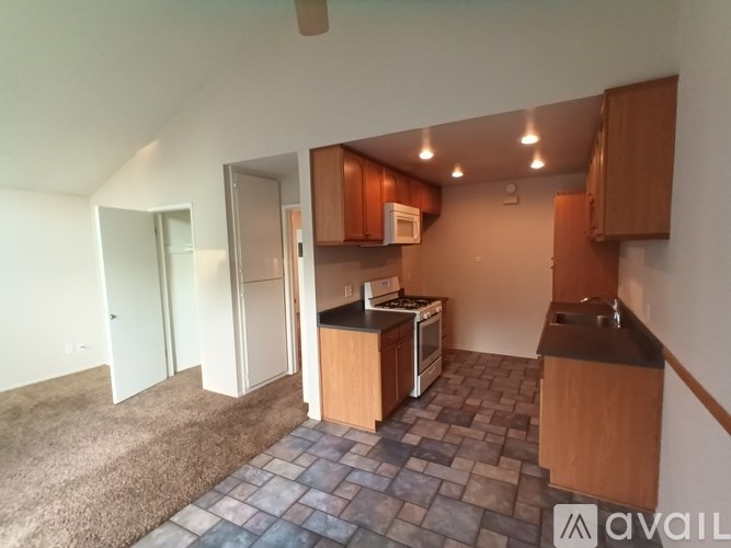 A kitchen with a tile floor and wooden cabinets.