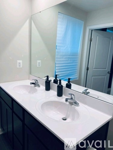 A bathroom with a white countertop and two sinks.