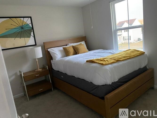 A bedroom with a bed, nightstand, and lamp.