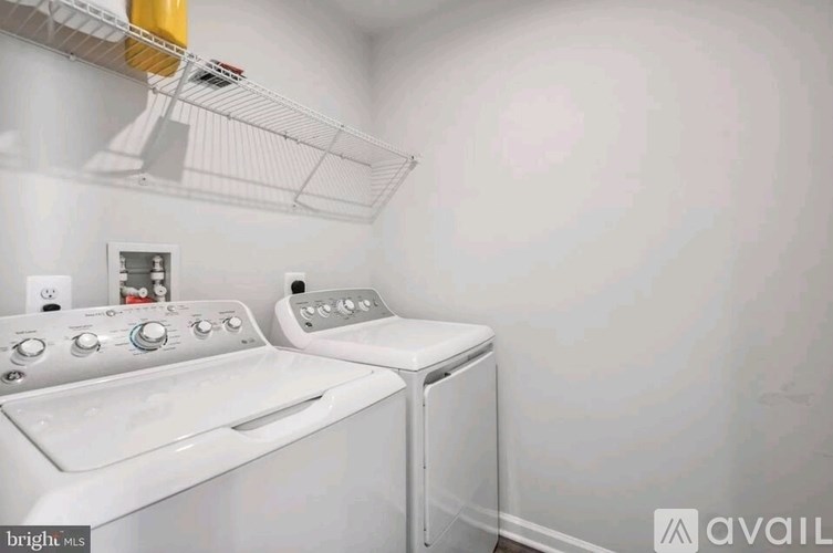 A white washing machine and dryer in a laundry room.