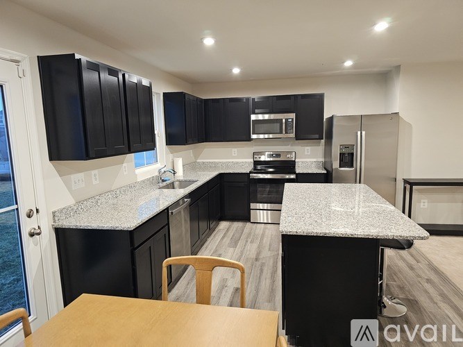 A kitchen with black cabinets and a granite countertop.