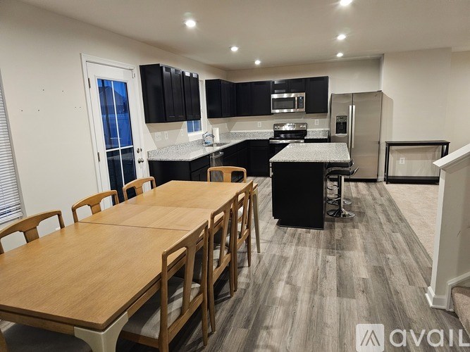 A kitchen with a dining table and chairs is available for rent.