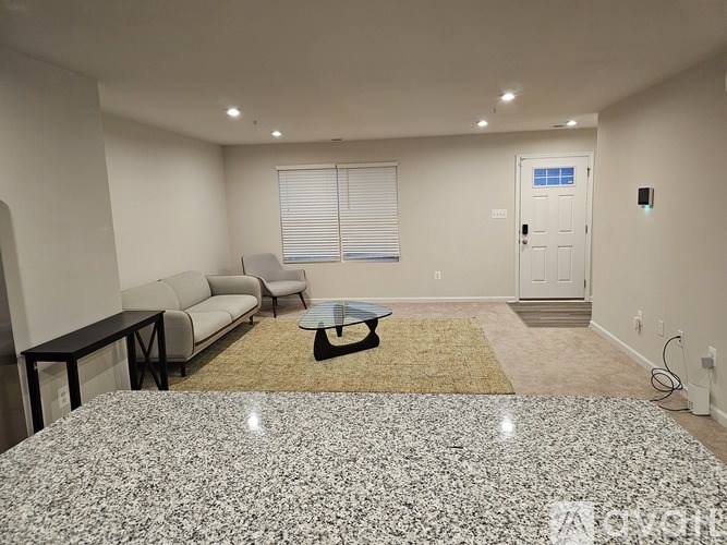 A living room with a grey granite countertop and a white sofa.