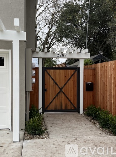 A wooden gate with the number 2287 on a white post.