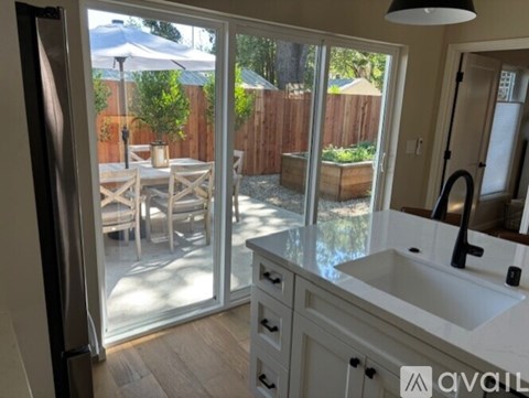 A kitchen with a sink and a refrigerator with a glass door.