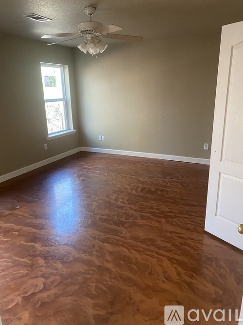 A room with a ceiling fan and a door.