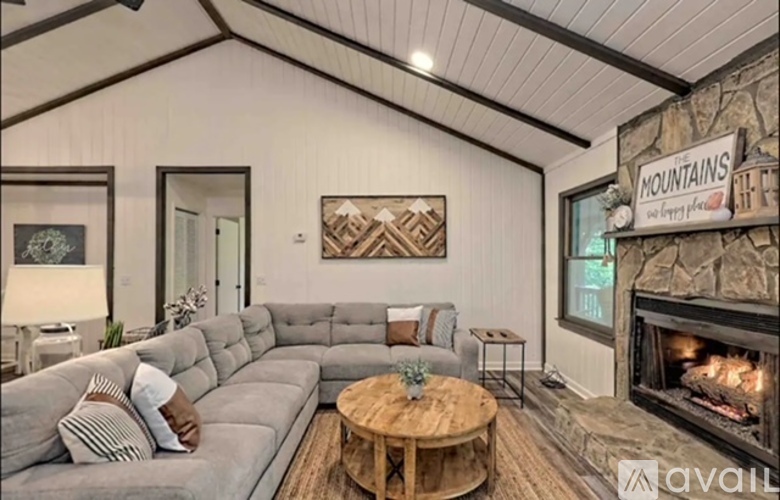 A living room with a grey couch and a fireplace.
