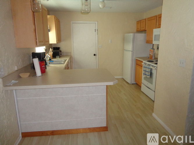 A kitchen with a white refrigerator and wooden cabinets.