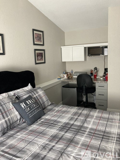 A bedroom with a bed, desk, and chair.