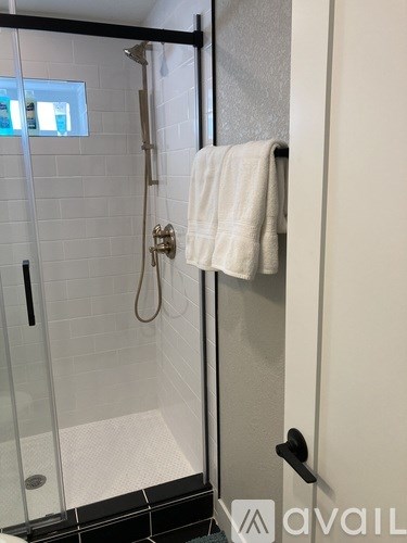 A white towel is hanging on a black door handle.
