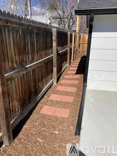 A wooden fence with a brick pathway running through it.