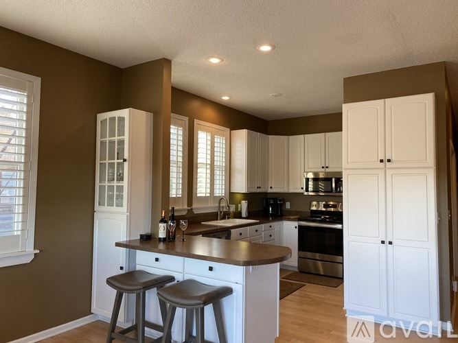 A kitchen with white cabinets and a wooden island.
