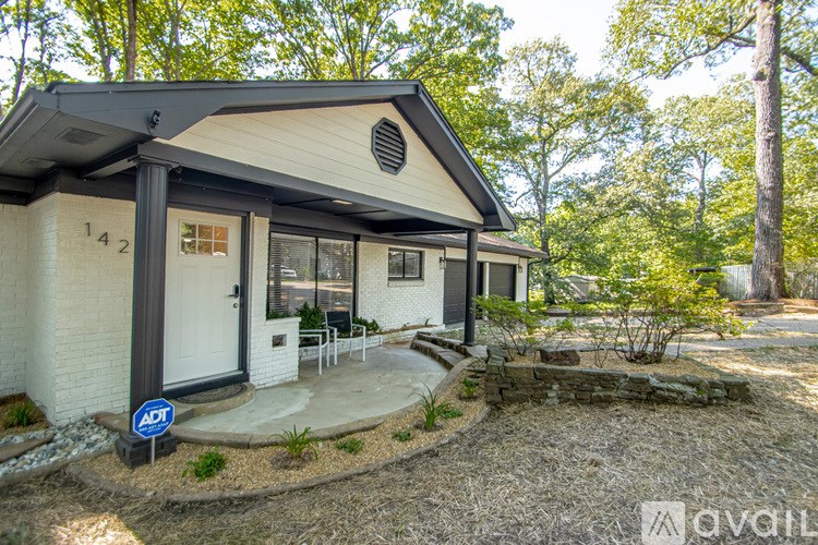 A small house with a porch and a sign that says "ADT" in front of it.