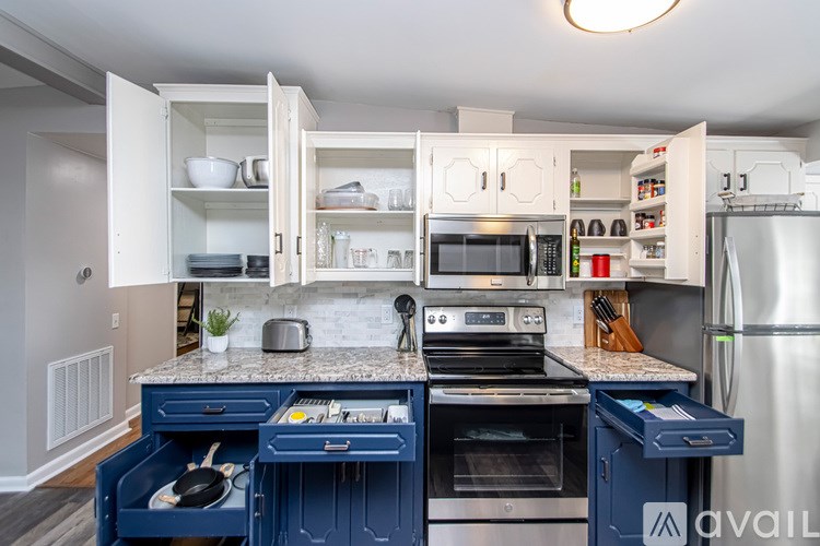 A kitchen with a granite countertop and blue drawers.