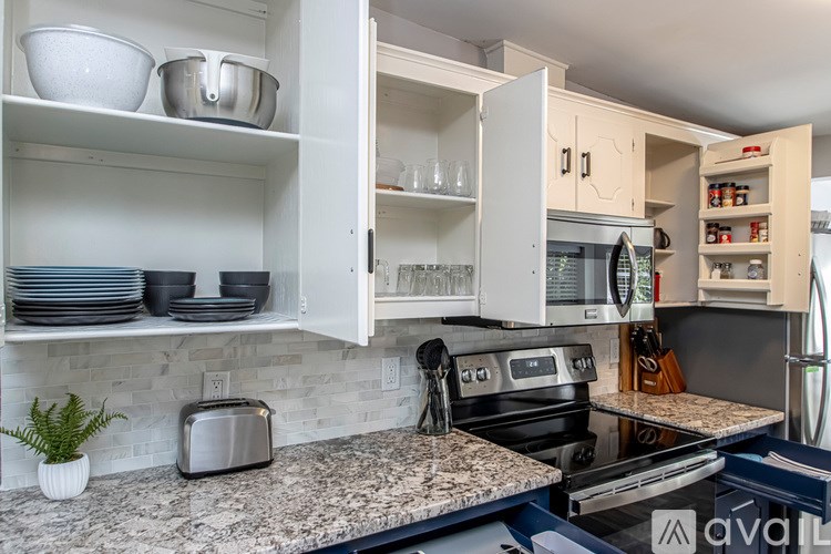 A kitchen with a granite countertop and a silver toaster.